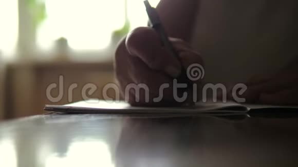 一位坐在餐桌上的老妇人手工书写的特写视频的预览图