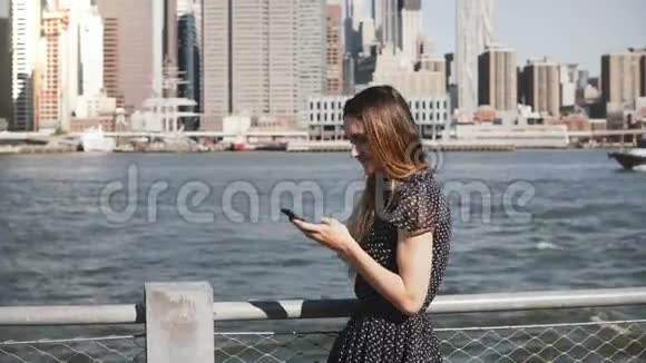 美丽的年轻白种人女孩长发沿着纽约曼哈顿天际线打电话和交谈视频的预览图