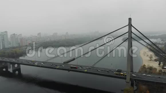 大的混凝土灰色桥梁在宽阔的河流上有钢索乘坐城市中心大宽带桥的汽车和公共汽车空中交通视频的预览图