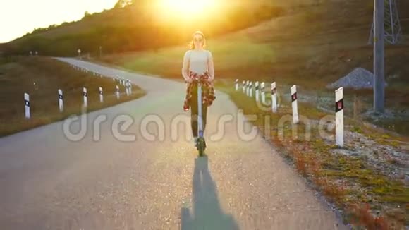 在夕阳下骑电动滑板车的女孩视频的预览图
