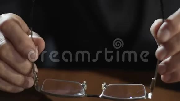 成年商人手拿眼镜放在桌子上律师视频的预览图