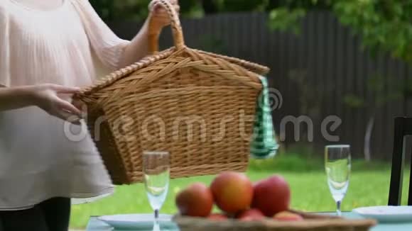 漂亮的女士把野餐篮放在桌子上男人抱着她看着摄像机视频的预览图