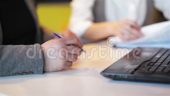 两个商人在AAN办公室围着一张木桌人在纸上写文字视频的预览图