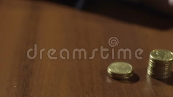桌上成排的硬币堆在沙漏中流动的沙子上视频的预览图