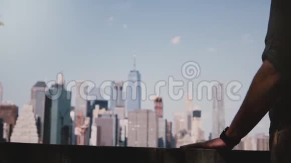 在纽约曼哈顿的河岸风景天际线上一个面目全非的人把手放在水泥栅栏上和栅栏下视频的预览图