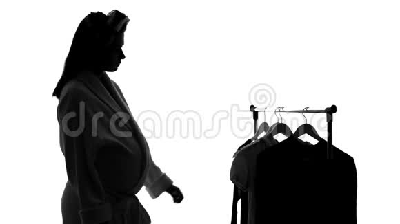 悲伤的孕妇站在镜子前试穿旧衣服怀旧视频的预览图
