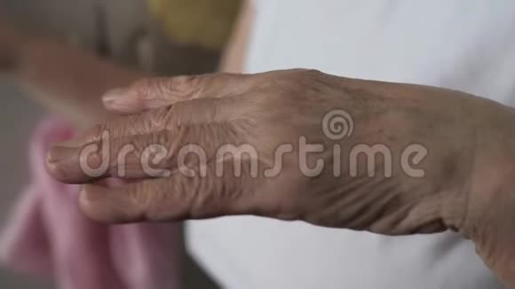 一位老妇人颤抖着颤抖着手的特写镜头视频的预览图
