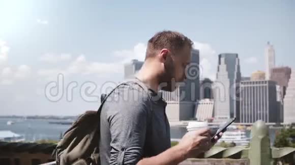 快乐自信的白种人自由职业者带着咖啡和智能手机在美丽的纽约市全景中漫步视频的预览图