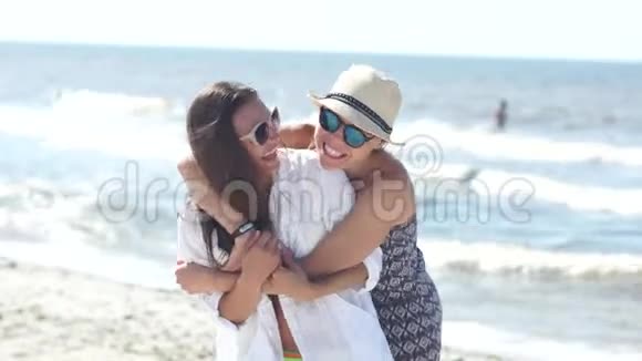 在阳光明媚的炎热天气里姐妹们拥抱站在海滩上家庭假日暑假视频的预览图