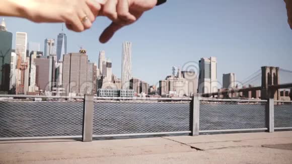 快乐的欧洲旅游情侣牵着双手举起手臂奔向曼哈顿令人惊叹的天际线布鲁克林大桥慢动作视频的预览图