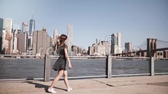 在美丽的曼哈顿天际线景色中头发随风飘动的女孩的后景手臂张开缓慢的运动视频的预览图