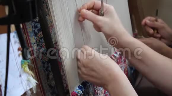手工编织的丝绸地毯两个女人手工编织丝绸地毯视频的预览图