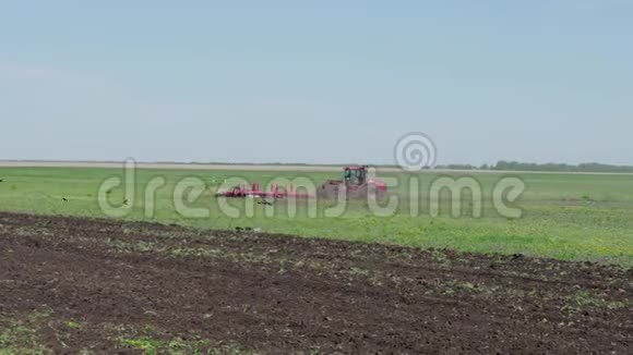 早春季节农民在拖拉机上用播种机整地作为播种前活动的一部分视频的预览图