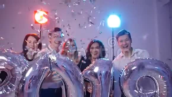 新年2019概念一群兴高采烈的年轻人拿着数字气球用五彩纸屑洗澡视频的预览图