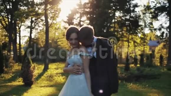 秋天阳光明媚幸福的新婚夫妇在公园拥抱视频的预览图