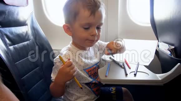 4k小男孩在飞机上长时间飞行时用铅笔画画的视频视频的预览图