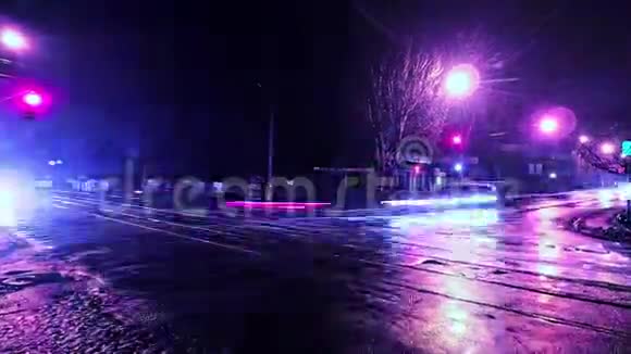 在湿沥青上反射交通和灯光的延时夜市交叉口视频的预览图