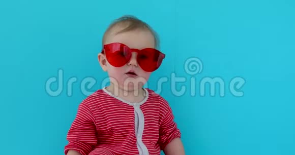 可爱的宝宝带着带红色太阳镜的孩子视频的预览图
