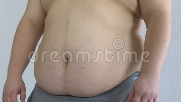 悲伤的男性检查他肥胖的身体触摸胃拉伸痕迹和纤维素视频的预览图