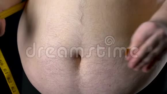 胖子用黄色胶带测量他的腹部控制体重饮食结果视频的预览图