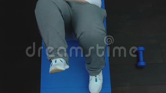 健身课期间懒洋洋的胖乎乎的雄性在运动垫上做自行车运动视频的预览图