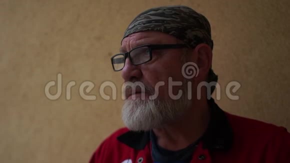 一位戴眼镜戴头带满脸灰胡子的微笑男子的特写肖像视频的预览图