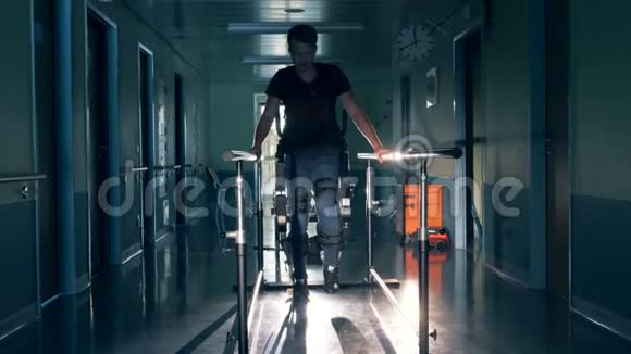 一名男子在一个诊所里使用机器人矫形器行走在跑道上4K视频的预览图