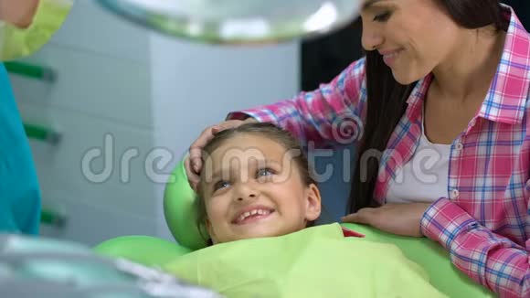 专业的儿科牙医在手术前安抚儿童给予高五视频的预览图