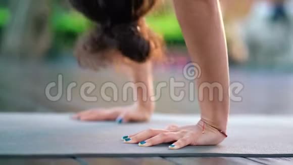 年轻女子有东方的外表独自在热带岛屿的木制甲板上练习瑜伽穿灰色衣服的女孩视频的预览图