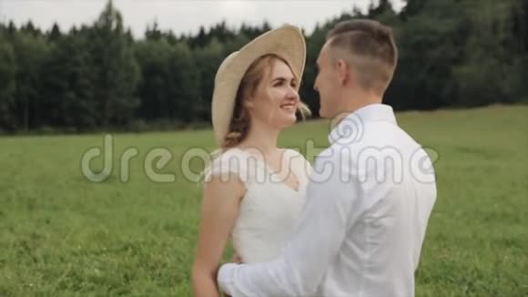 新娘和新郎面对面地站在草地上背景是森林慢动作视频的预览图