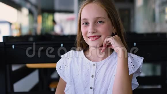 迷人的年轻女孩展望相机和微笑的肖像近距离射击视频的预览图