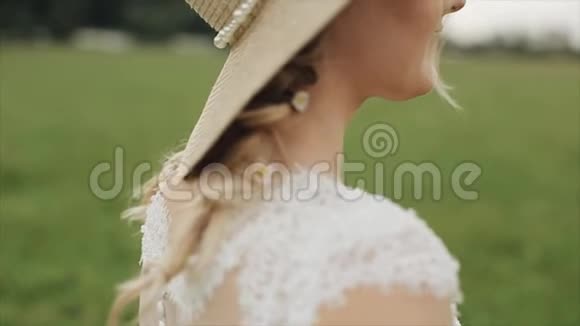 在模糊的绿色背景下一位美丽的新娘站在户外的侧面近景视频的预览图