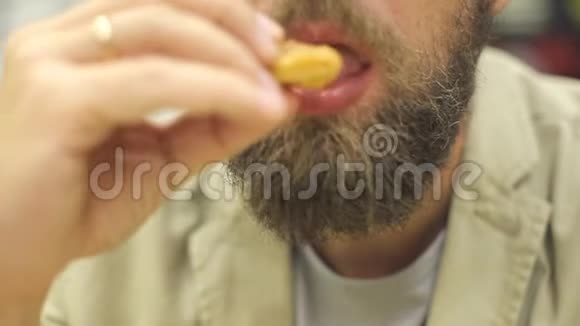 一个留胡子的白种人在快餐店吃炸鸡翅和金块视频的预览图