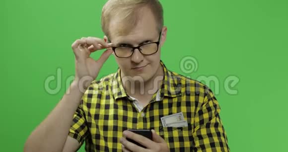 戴眼镜的白人男子手中拿着手机滚动或发短信视频的预览图