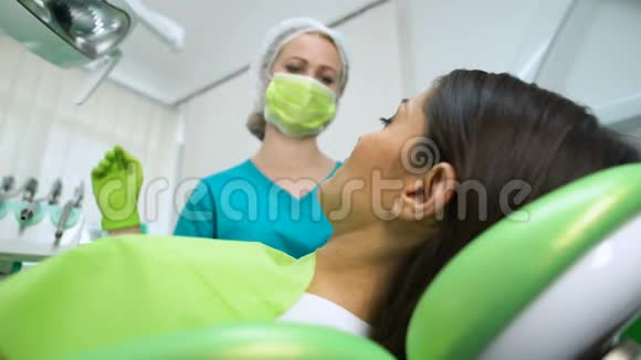 牙科医生为年轻妇女治疗牙齿去除龋齿放置牙科密封胶视频的预览图