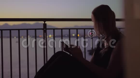 站在阳台上看海景的年轻女子视频的预览图
