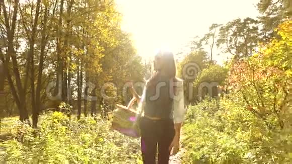 年轻女子在秋天的森林里散步手里拿着一个野餐篮慢动作安定夹视频的预览图
