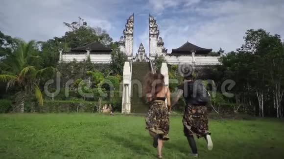 年轻的幸福夫妇牵着手朝丛林中的曼迪尔跑去视频的预览图