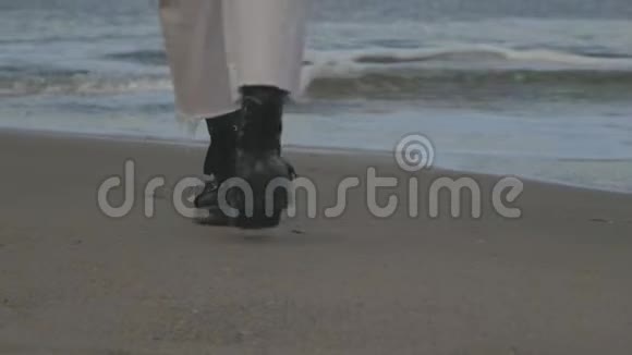 穿着皮鞋的腿在海边的沙滩上行走视频的预览图