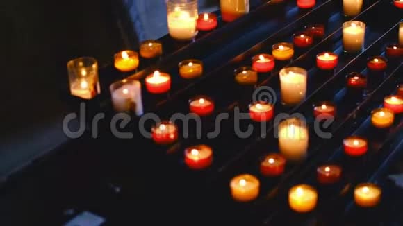 无数的蜡烛在一个非常黑暗的天主教教堂的内部点燃视频的预览图
