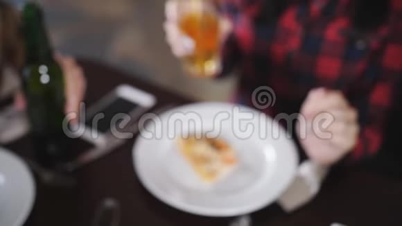 公司的美女们在披萨店里咯咯地喝着瓶啤酒特写镜头视频的预览图