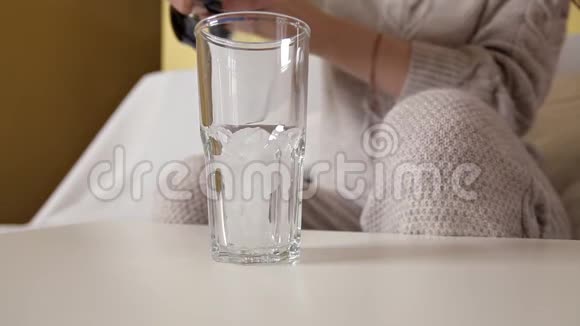 一个女孩坐在沙发上把可乐倒进杯子里视频的预览图