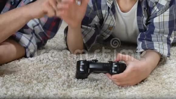 男人教儿子玩电子游戏回家一起享受时光爸爸帮忙视频的预览图