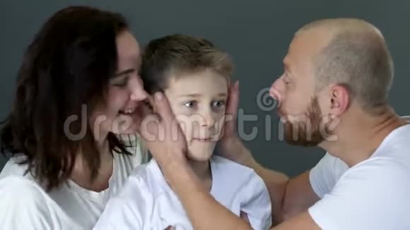 爱的家人穿着相同的白色T恤衫在摄影棚里互相拥抱视频的预览图
