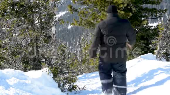 冬天一个人在晴朗的天气里穿过厚厚的雪视频的预览图