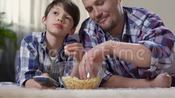 可爱的男孩和爸爸一起看电影享受和他父亲的时光家人的爱视频的预览图