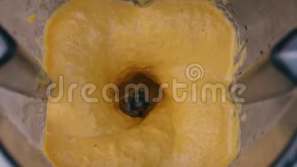 在搅拌机中混合橙色和黄色成分上景准备蔬菜酱素食和素食食品视频的预览图