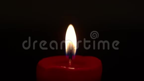 红色圆形蜡烛光火焰燃烧隔离在黑色的黑暗背景上关闭宏观拍摄在低键视频的预览图