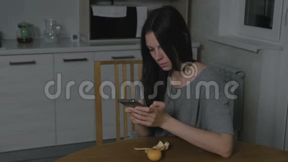 单身的年轻女子晚上在厨房里输入一条信息视频的预览图