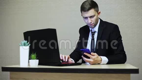 英俊的商人在办公室工作在笔记本电脑上打字视频的预览图